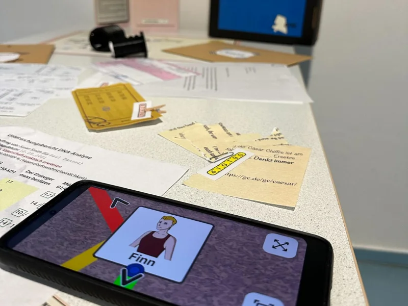HOLA game assets including character envelopes, the 3D-printed cipher wheel, clue documents, and the companion app